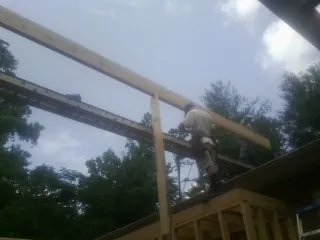 Carpenter setting a ridge beam over a new addition frame — Ice Dam Removal by Roofing Brothers in New Berlinville