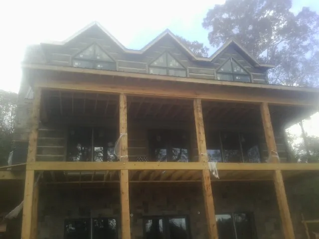Dormers and porch framing on a large log home under construction — Roof Coating work by our crew in New Berlinville