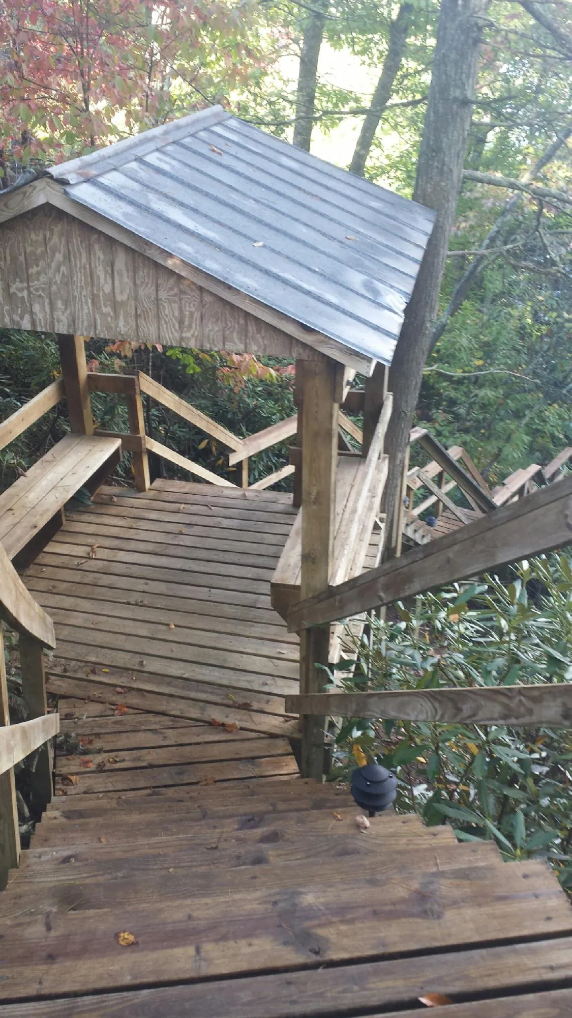 Metal roofed shelter over wooden steps on a wooded walkway — Skylight Repair & Installation work by our crew in New Berlinville
