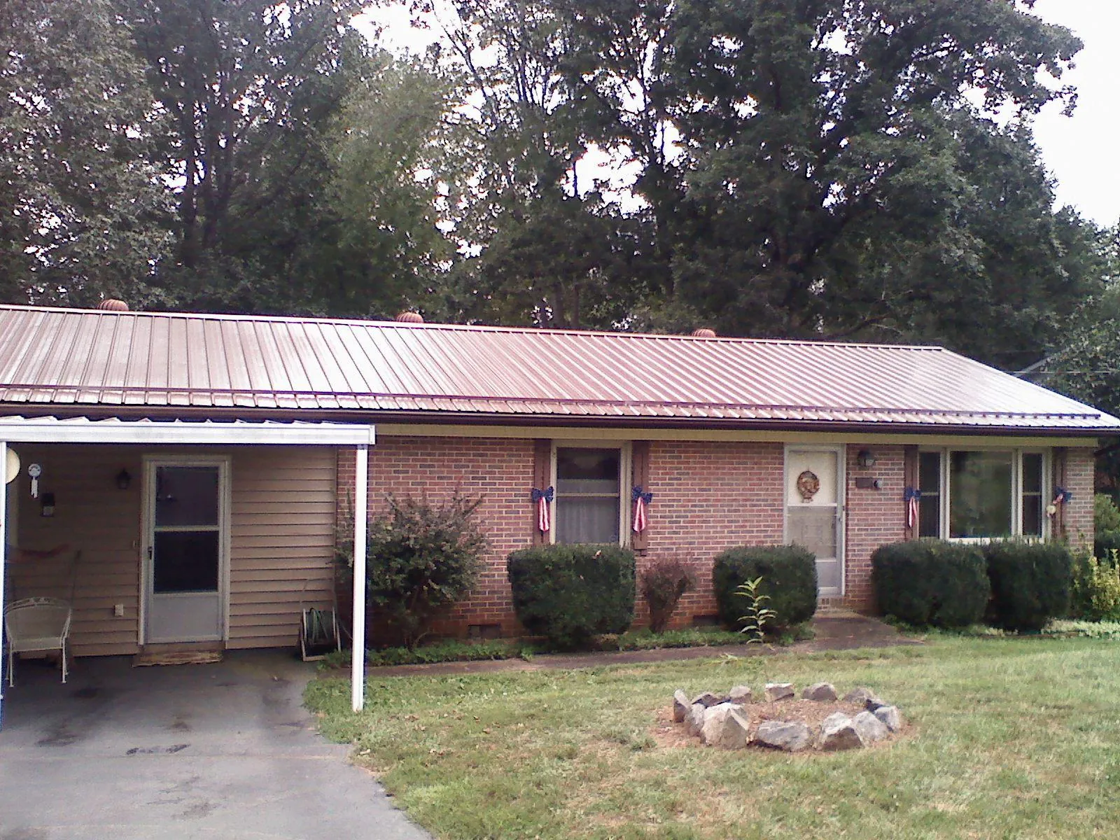 Bronze metal roof and carport on a brick ranch home — Roof Repair work by our crew in New Berlinville